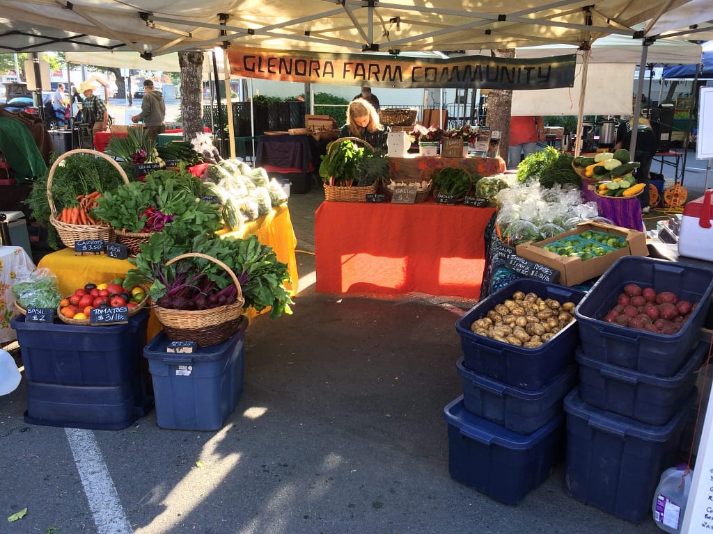 A market stand overflows with fresh produce at a local farmer's market.